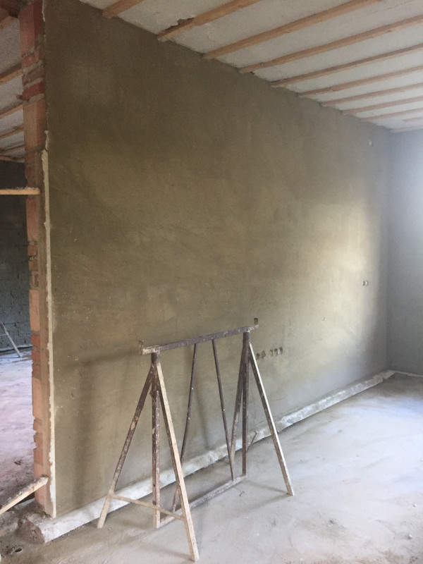 De eerste stuclaag in wat de woonkamer wordt.